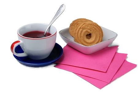Cup of tea with spoon on a blue plate and cookies  isolated on a white background.の写真素材