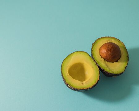 Fresh avocado with seed, avocado halves on blue background. Top view. Creative summer food concept.Ripe avocadoの写真素材