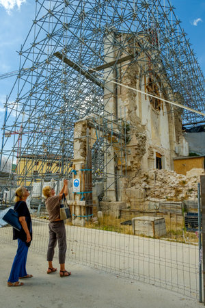 Two women looking at the remains of the Basilica of San Benedetto da Norcia in Italy, destroyed by the earthquake of 30 October 2016.のeditorial素材