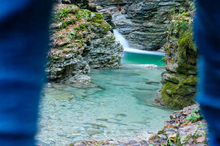 A hiker is looking at the clear waters of the Rui stream, Mel, Belluno, Italyの写真素材