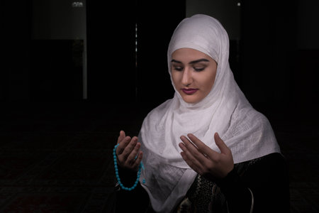 Girl with hijab praying in darkの写真素材