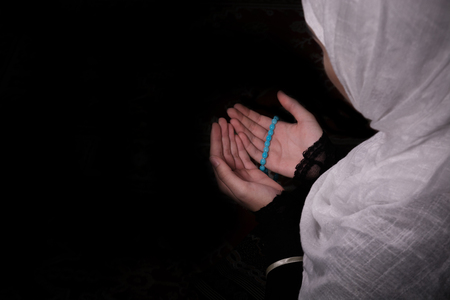 Muslim woman praying in darkの写真素材