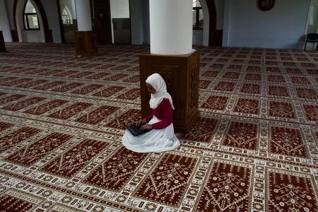 Muslim girl in mosque typing on laptopのeditorial素材