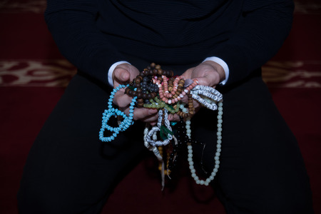 Muslim man holding tasbih in handsの写真素材