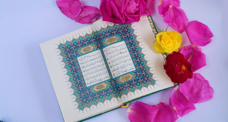 Koran with roses isolated on white backgroundの写真素材