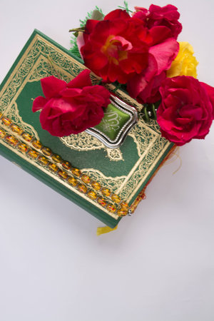 Koran with roses isolated on white backgroundの写真素材