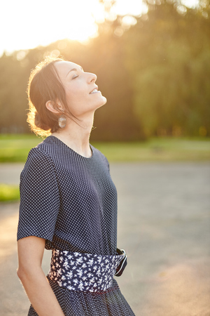 girl enjoys gentle sunshine in gardenの写真素材