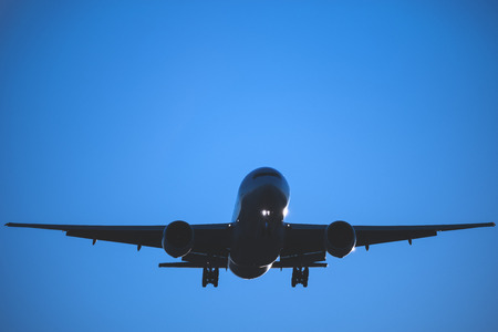 Landing of the passenger plane at sunset time.の写真素材