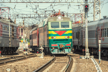 Passenger trains move on the station at day time.