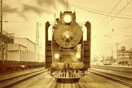 Retro steam train stands on the station at sunset time.のeditorial素材