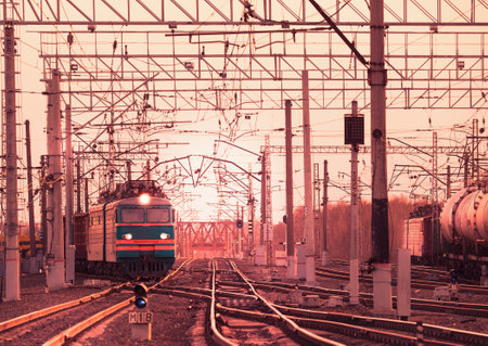 Two long freight trains moves through the station at evening time.のeditorial素材