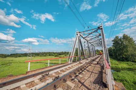 Freight train appoach to the railway bridge over the river.の写真素材