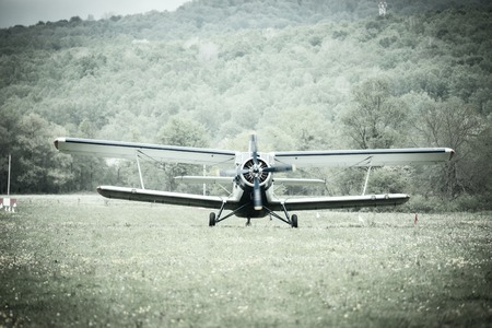 Landing of the old retro plane on the meadow.の写真素材