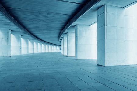 Long wide corridor of the building with columns at summer day time.
