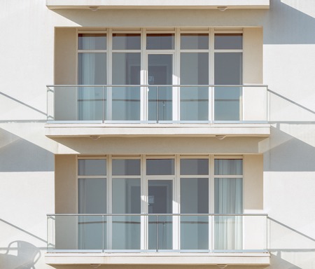 Windows and balconies of the new townhouse at sunset time.