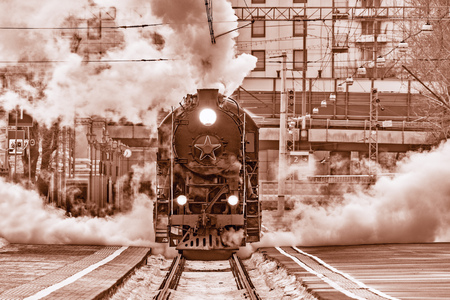Retro steam train departs from the station.の写真素材
