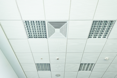 White office ceiling with lighting and ventilation equipment.の写真素材