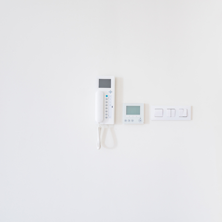 Wall display for air temperature, switch and intercom handset on the apartment room wall.