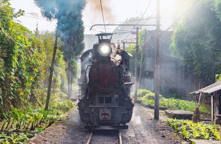 Steam narrow-gauge train moves from Yuejin to Shixi through the village. Jiayang Mining Region....