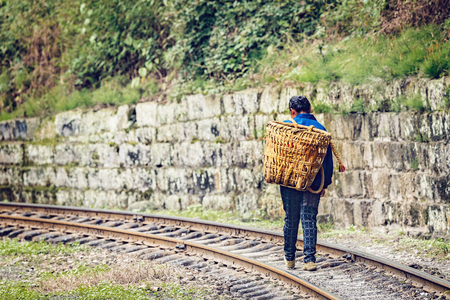 Local woman with basket moves from Bagou to Yuejin. Jiayang Mining Region. Sichuan province. China.の写真素材