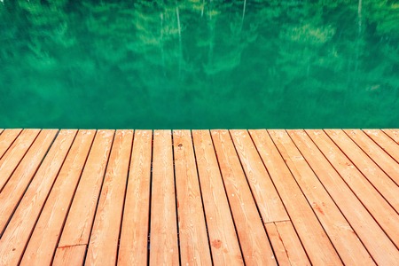 Wooden bridge edge by the forest lake.の写真素材