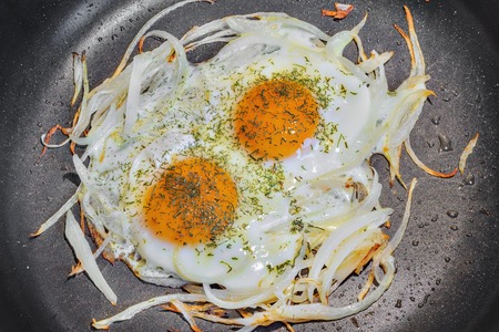 Fried eggs with onion and fennel on the pan.の写真素材