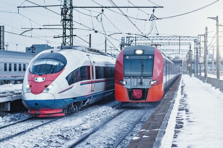 Two modern high-speed trains moves fast at winter day time.の写真素材