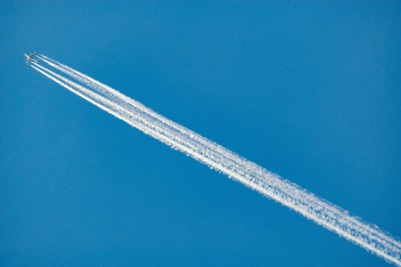 A long trail of jet plane on blue sky background.の写真素材