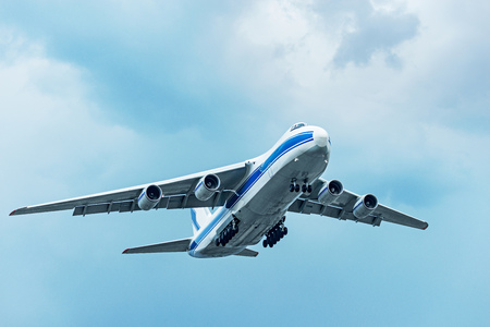 Flight of the big cargo airliner at cloudy day time.