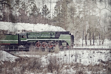 Steam train moves forward at cold winter morning time.の写真素材