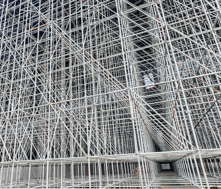 Vertical scaffolding formed a myriad of grid. Industrial and modern urban construction background.