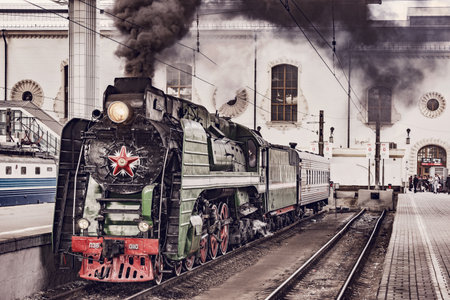Moscow, Russia - May 25, 2019: Retro train before departure stands by Kazan railway station building.のeditorial素材