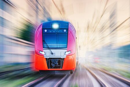 Passenger train moves fast at sunset time.