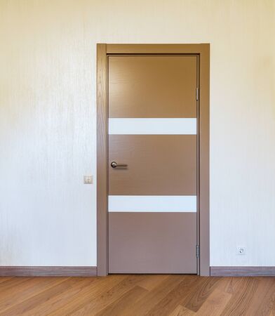 Closed wooden door in the flat room.の写真素材