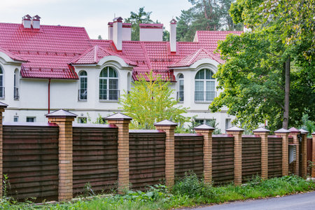 Korolev, Russia - August 14, 2019: Wooden fence by the prestige townhouses in the forest.のeditorial素材