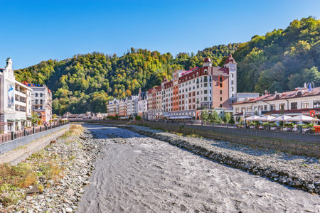 Krasnaya Polyana, Russia., October 10, 2019: Hotels, shops and restaurants along Mzymta river at autumn sunny day time.のeditorial素材