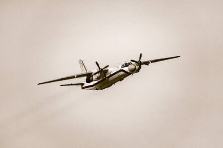 Passenger retro plane in the clear sky at evening time.