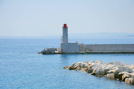 Lighthouse by the city port.の写真素材