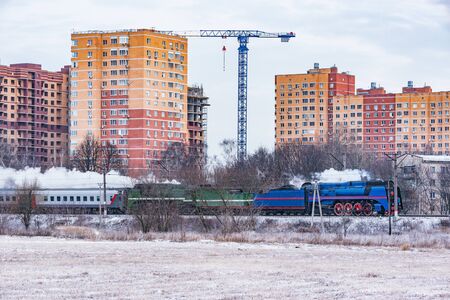 Retro steam train moves at winter morning time.の写真素材