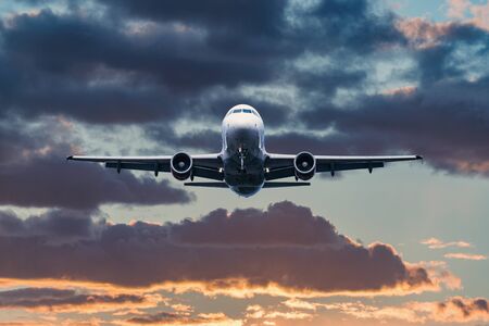Landing of the passenger plane at sunset time.