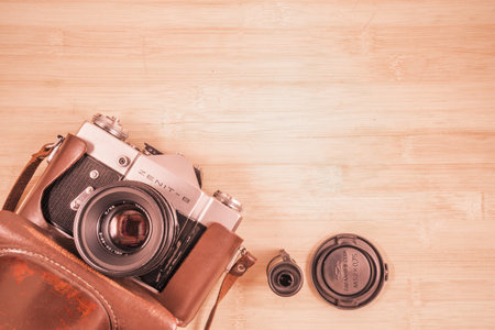 Korolev, Russia - January 07, 2015: Old vintage photo-camera and tape cassette on wooden background.のeditorial素材