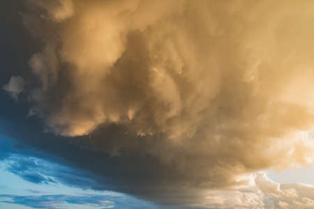 Dark storm clouds before rain at sunset.の写真素材