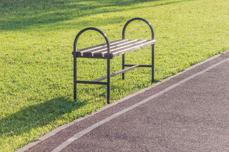 Bench by the small road in the park.の写真素材