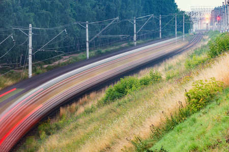Blurred image of the passenger train by the forest.の写真素材