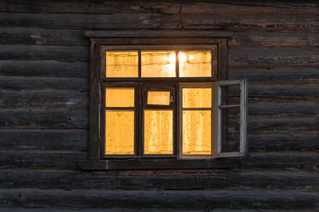 Window of the wooden ancient house at night time.の写真素材