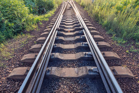 Railway tracks on the station at evening time.の写真素材