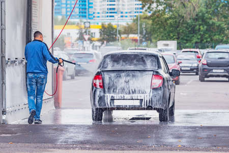 Man washes his car on the open air.の写真素材