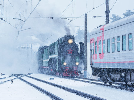 Monino, Russia - February 23, 2020: Retro steam locomotive approaches to the train carriage.のeditorial素材