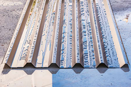 Wet corrugated metal fence sheet by the construction site.の写真素材