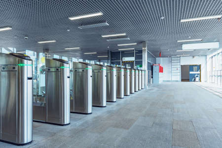 Turnstiles with electronic card readers on the station platform.の写真素材